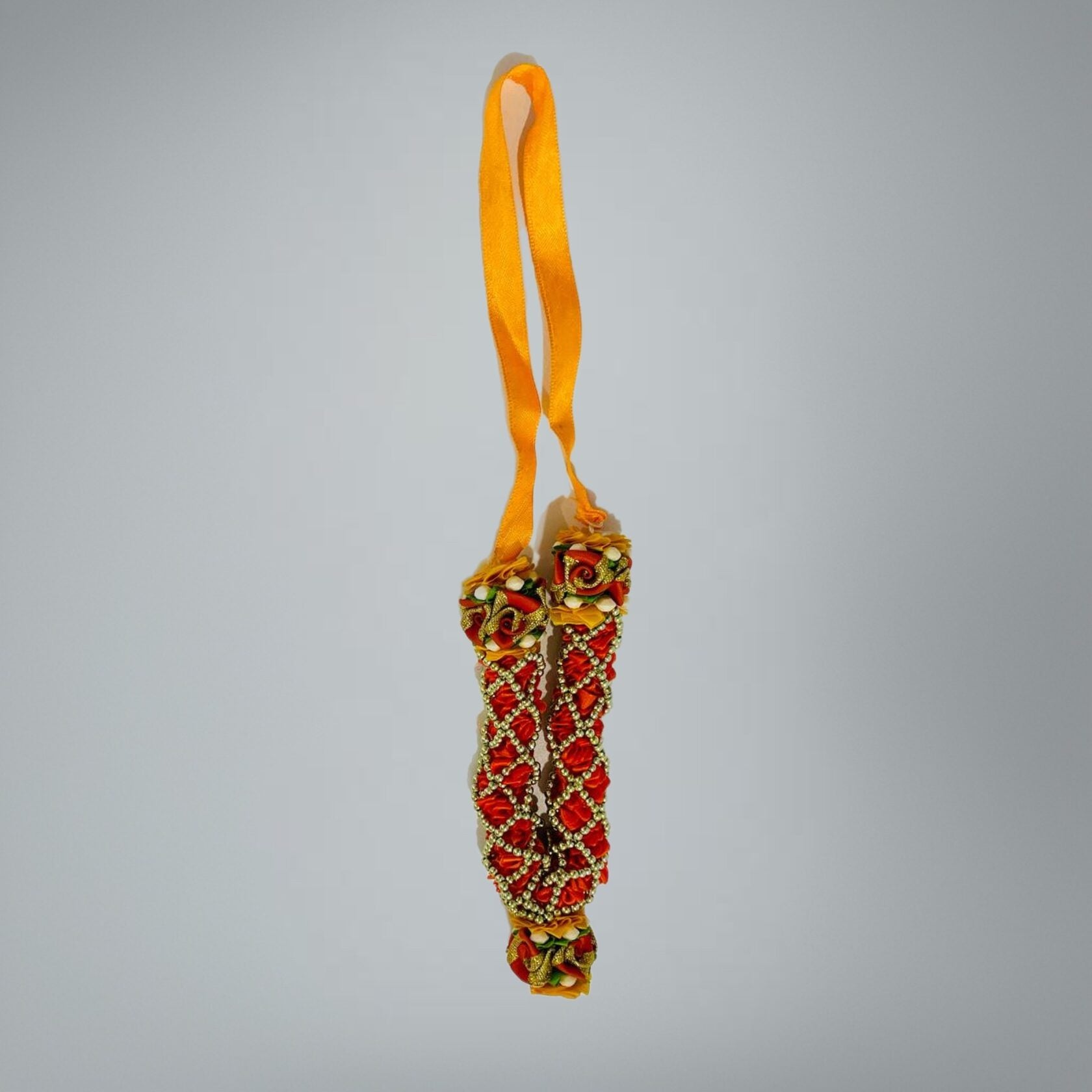 Deity garland placed alongside puja items on altar - Bhakti Shop